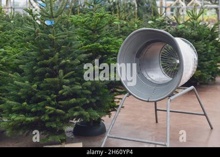 Weihnachtsbaum-Wickelvorrichtung verpackt in einem Plastiknetz Stockfoto