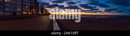 Panoramablick auf einen leeren Strand von Sint-Idesbald in Koksijde mit einem schönen Abendlicht bei Sonnenuntergang Stockfoto