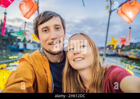 Ein glückliches Paar von Reisenden fährt auf einem Nationalboot auf dem Hintergrund der alten Stadt Hoi in Vietnam. Vietnam öffnet sich nach der Quarantäne wieder für Touristen Stockfoto