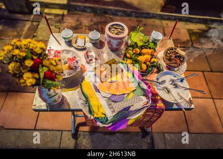 Der Tisch ist mit Geschenken an die Götter bedeckt. Opfergabe an die Götter in Vietnam Stockfoto