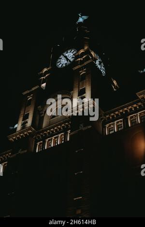 Vertikale Low-Angle-Aufnahme des Uhrturms in der Nacht. Stockfoto