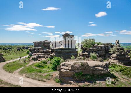 Yorkshire UK Sommer, Blick auf Menschen, die an stark erodierten Felsformationen bei Brimham Rocks in Nidderdale, North Yorkshire, England, vorbeilaufen Stockfoto