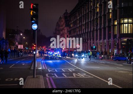 LONDON - 1. NOVEMBER 2021: Ein Motorradfahrer der Polizei blockiert die Straße vor den Houses of Parliament während des Millionenmaskenmarsches Stockfoto