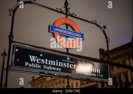 LONDON - 1. NOVEMBER 2021: Schild am Eingang der Westminster Underground Station bei Nacht Stockfoto