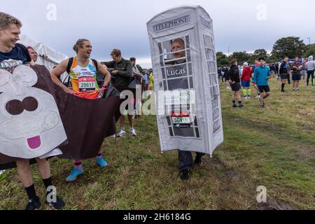 Vor dem Rennen versammeln sich im Greewich Park schicke Läufer in verschiedenen Kostümen im Vorfeld des London-Marathons 2021. Über 40,000 Läufer nahmen daran Teil. Stockfoto