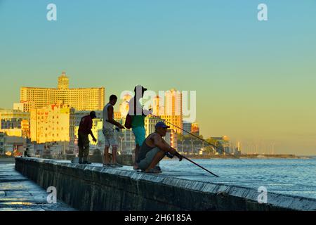 Malecón (offiziell Avenida de Maceo) hat am Morgen auf der Ufermauer geschilderte Fischer aufgestellt. La Habana (Havanna), Habana, Kuba Stockfoto