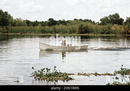 Zwei Jungen in einem kleinen Boot fischen in Bayou Gauche, in den Feuchtgebieten von Louisiana, ca. August 1972 Stockfoto