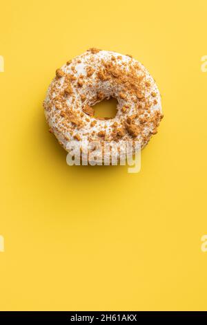 Süßer glasierter Donut mit Streuseln auf gelbem Hintergrund. Draufsicht. Stockfoto