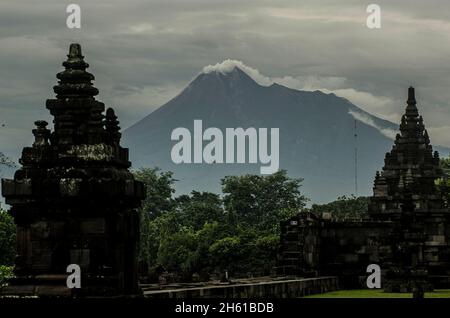 Yogyakarta, Indonesien. November 2021. Das am 12. November 2021 aufgenommene Foto zeigt weiße Rauchwolken, die vom Berg Merapi aus gesehen vom Prambanan-Tempelkomplex im Sleman-Bezirk, Yogyakarta, Indonesien, spucken. Quelle: Supriyanto/Xinhua/Alamy Live News Stockfoto