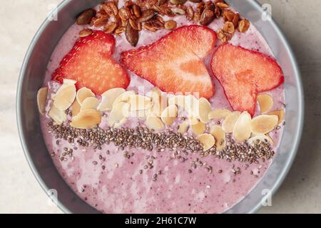 Frühstückssmoothie-Schüssel mit Chiasamen, Haferflocken, Mandeln und Erdbeeren. Gesundes Entgiftungskonzept Stockfoto