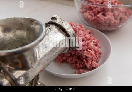 Hackfleisch mit einem manuellen Zerkleiner zu Hause zerkleinern. Stockfoto