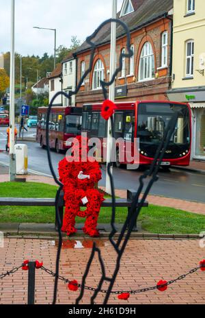 Chensham, Großbritannien. November 2021. Anlässlich des Gedenktages und des Erinnerungssonntags wurde ein Mohnmann aus gestrickten Mohnblumen mit einer weißen Taube auf einer Bank in der Nähe des war Memorial im Stadtzentrum von Chesham aufgestellt.Quelle: Maureen McLean/Alamy Live News Stockfoto