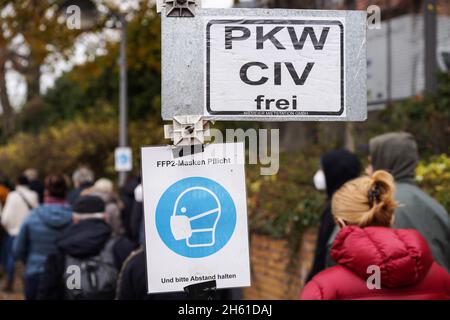 Berlin, Deutschland. November 2021. Ein Schild, auf dem Menschen mit Gesichtsmasken und Abstand zu sehen sind, ist vor einem Impfzentrum in Berlin, Hauptstadt von Deutschland, am 12. November 2021 zu sehen. Quelle: Stefan Zeitz/Xinhua/Alamy Live News Stockfoto