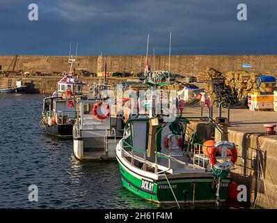 FINDOCHTY VILLAGE MORAY COAST SCOTLAND ANGELAUSRÜSTUNG UND BOOTE LIEGEN AN DER HAFENMAUER Stockfoto