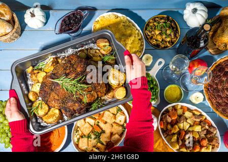 Thanksgiving-Esstisch mit neuen traditionellen Danksagungsessen - Huhn, Kartoffelpüree, grüne Bohnen, Pekannüsse, gebackenes Schweinefleisch, mac und che Stockfoto