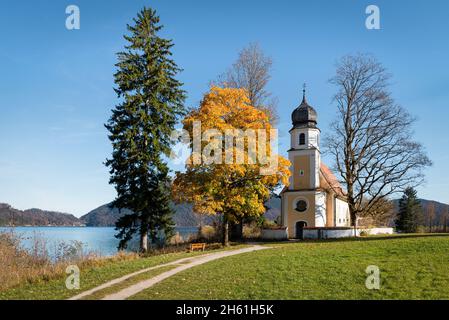 Die Barockkirche St. Margareth auf der Halbinsel Zwergern im Walchensee mit herbstbunten Bäumen, Bayern, Deutschland Stockfoto