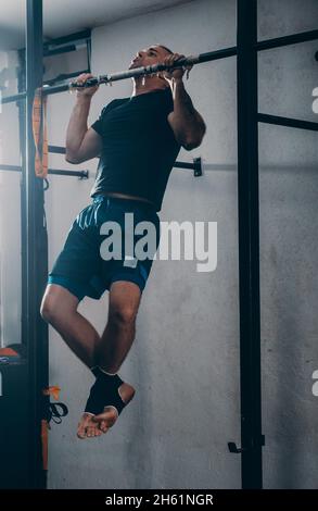 Fitness mensch Ausübung auf Klimmzugstange. Kerl, chin-ups Ausbildung getönten Arme portrait außerhalb Stockfoto