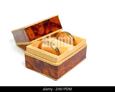 Goldene Eheringe in einer Schachtel vor weißem Hintergrund Stockfoto