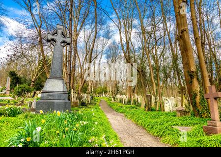 Pfad gesäumt von Grabsteinen auf dem Highgate Cemetery East, London, Großbritannien Stockfoto