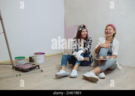 Inneneinrichtung. Zwei nette Mädchen Designer und Maler machen Reparaturen im Haus.Ein Team von Dekorateuren Stockfoto