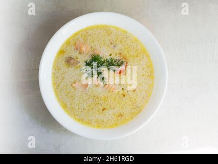 Lachs- und Cremefischsuppe in einer weißen Schüssel mit einem Dill-Zweig. Lohikeitto ist eine traditionelle finnische und karelische Suppe. Draufsicht. Stockfoto