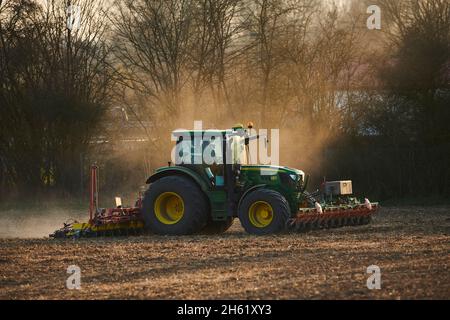 Traktor mit Egge auf einem Feld, Landwirtschaft, Sonnenuntergang, bayern, deutschland Stockfoto