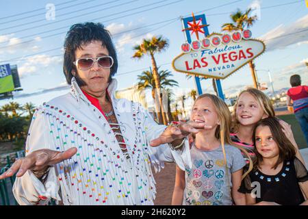 Las Vegas Nevada, The Strip, Willkommen im fabelhaften Las Vegas Schild historischer Mann, Elvis Presley Imitator Berühmtheit Look-alike Mädchen Kinder Stockfoto