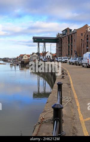 Altes Getreidegebäude mit seiner markanten überhängenden Gantry, jetzt Wohnwohnungen im Hafen in Wells-next-the-Sea, Norfolk, England, Großbritannien. Stockfoto