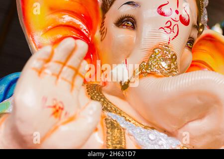 Gott Ganesha farbenfrohe Elefantenstatue zum Hindu Festival Ganesha Chaturthin in Indien zu feiern. Das Om-Symbol auf dem Gesicht und das Sri-Symbol auf der Hand Stockfoto