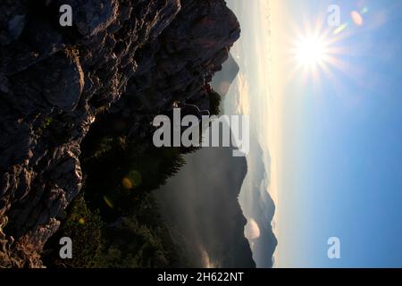 Mann über der Wolkendecke bei einer Wanderung zum Gipfel der kampenwand (1669 m) im chiemgau,Sonne,Rücklicht,chiemgauer alpen,bei aschau,oberbayern,bayern,süddeutschland,deutschland Stockfoto