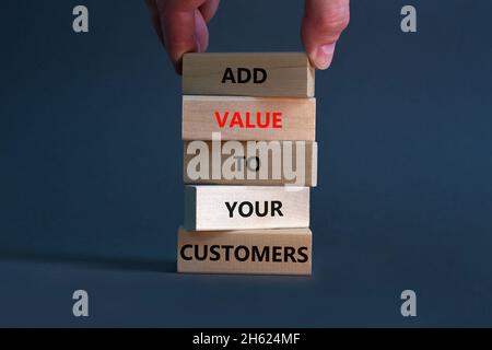Erhöhen Sie den Wert Ihres Kunden-Symbols. Konzeptwörter „Mehrwert für Ihre Kunden“ auf Holzblöcken auf einem schönen grauen Hintergrund, Kopierfläche. Businessm Stockfoto