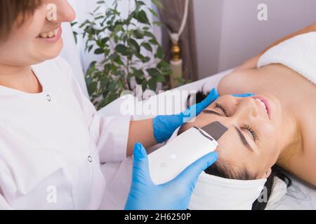 Junge hübsche Frau erhalten Ultraschall Reinigung Gesichtsbehandlung im Schönheitssalon, Kosmetik Gesichtsbehandlung Konzept. Stockfoto