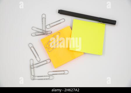 Selektiver Fokus auf bunte Haftnotizen und Büroklammern. Flach liegend, Draufsicht. Speicherplatz kopieren. Stockfoto