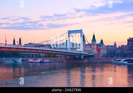 Der wunderschöne violette Sonnenaufgang über der Donau, die Elisabeth-Brücke und der historische Damm des Pest-Viertels mit der Pfarrkirche der Inneren Stadt hinter dem bri Stockfoto