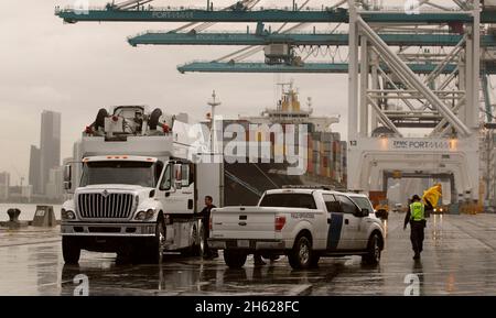 Ein US-Zoll- und Grenzschutzbeamter und ein Mitbeamter wickeln das Scannen von Schiffscontainern ab, während sie ankommende Fracht im Hafen von Miami in Miami, Florida, inspizieren., 07. Dezember 2015. Stockfoto