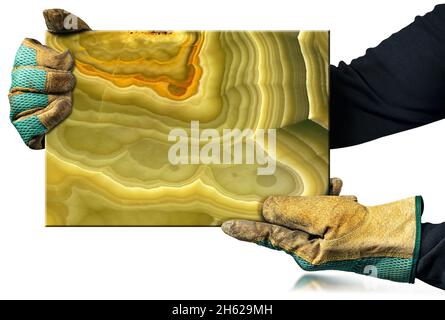 Manueller Arbeiter mit schützenden Arbeitshandschuhen, die eine Granitplatte aus Onyx halten, isoliert auf weißem Hintergrund mit Reflexionen. Stockfoto