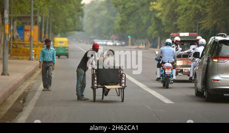 Während die Autokolonne des Verteidigungsministers Ash Carter ihren Weg zum India Gate in Neu-Delhi, Indien, einbahnt, geht das tägliche Leben der Einheimischen am 3. Juni 2015 weiter. Stockfoto