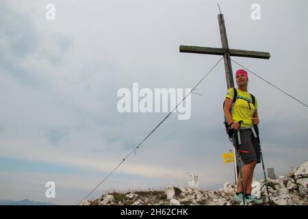 Frau beim Wandern auf dem Gipfel der Brunnsteinspitze (2197 Meter), von vorne, Gipfelkreuz im Hintergrund, österreich, tirol, scharnitz, Naturpark karwendel, Stockfoto