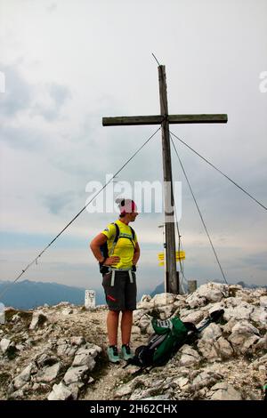 Frau beim Wandern auf dem Gipfel der Brunnsteinspitze (2197 Meter), von vorne, Gipfelkreuz im Hintergrund, österreich, tirol, scharnitz, Naturpark karwendel, Stockfoto