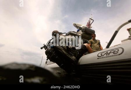 Ein Taucher der US-Grenzpatrouille BORSTAR betritt das Wasser mit einer Rückenrolle von der Seite eines SICHEREN Bootes während einer Such- und Rettungsübung in Panama-Stadt, Florida, 25. Mai 2016. Stockfoto