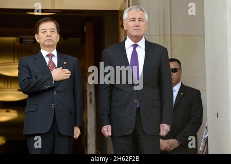 Chuck Hagel und Han Min Koo, Minister für nationale Verteidigung der Republik Korea, am Eingang zum Pentagon, wo ihre Nationalhymnen am 23. Oktober 2014 von einer Militärkapelle gespielt werden. Stockfoto