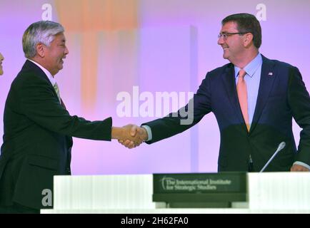 Der japanische Verteidigungsminister Gen Nakatani geht auf die Bühne, um Verteidigungsminister Ash Carter vor Carters Keynote beim Shangri-La-Dialog in Singapur am 30. Mai 2015 zu begrüßen. Stockfoto