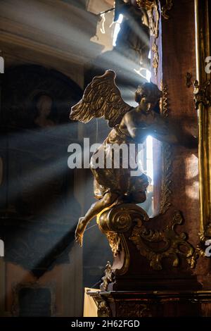 Staubpartikel, die gegen einen Sonnenstrahl aus einem Fenster in der Kirche strahlen. Kirche der Heiligen Apostel Petrus und Paulus in Lemberg Stockfoto