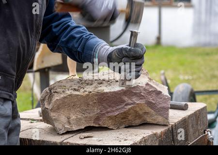 Sandstein wird für eine trockene Steinwand verarbeitet. Stockfoto