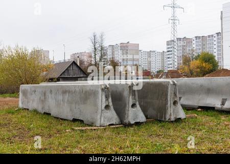 Betonstoßstangen auf einer Baustelle. Hackmaschinen für die Verkehrssicherheit. Stockfoto