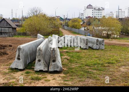 Betonstoßstangen auf einer Baustelle. Hackmaschinen für die Verkehrssicherheit. Stockfoto