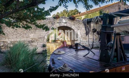 canal du Midi in le somail. Der Kanal ist ein unesco-Weltkulturerbe und wurde 1681 fertiggestellt. Er wurde von pierre paul riquet entworfen. Die Steinbrücke ist als Monument historique klassifiziert. Stockfoto