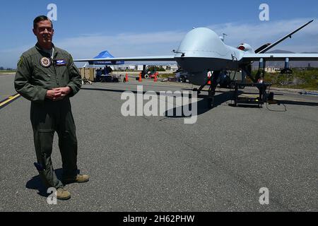 Berichterstattung: Air Force Maj. Scott Gregg, Projektleiter des Black Dart-Projekts, spricht vor einem unbemannten MQ-9-Flugzeugsystem auf dem Marinestützpunkt Ventura County and Sea Range, Point Mugu, Kalifornien, 31. Juli 2015 mit den Medien. Die Drohne, sagte Gregg, fliegt bei mehr als 18,000 Fuß und wiegt mehr als 1,300 Pfund. Es wurde als Teil der zweiwöchigen Black Dart Gegen-UAS-Demonstration vom 26. Juli bis 1. August verwendet, um Technologien, Taktiken und Techniken zu bewerten und zu verbessern, die vom DoD und seinen Partnern verwendet wurden. Stockfoto