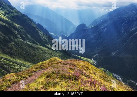 stimmungsvolle Atmosphäre in einer alpinen Berglandschaft im Sommer. Sonnenstrahlen brechen durch Wolken. maderanertal,glarner alpen,uri,schweiz,europa Stockfoto