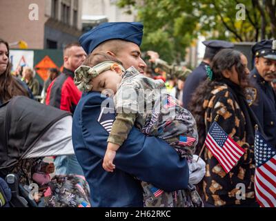 New York, New York, USA. November 2021. DER US-Luftwaffenmeister, Sergeant, carrys bei der Veterans Day Parade in NYC seine schlafende Camo, die seine Tochter bis zur fünften Welle trägt. Tausende grüßten, marschierten in der größten Veteranenparade der Nationen zu Ehren derer, die in den US-Streitkräften dienten. Im vergangenen Jahr wurde die Parade wegen Covid abgesagt. (Bild: © Milo Hess/ZUMA Press Wire) Stockfoto